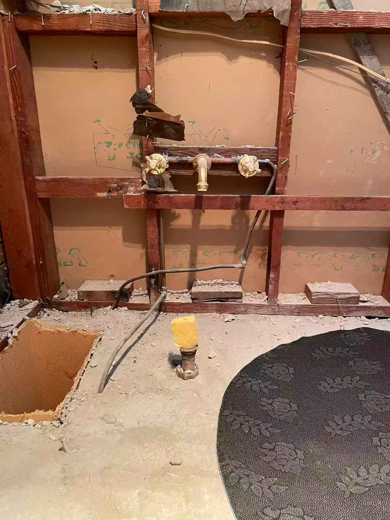 Owner-supplied bathroom renovation photo showing exposed original tap and pipe connections