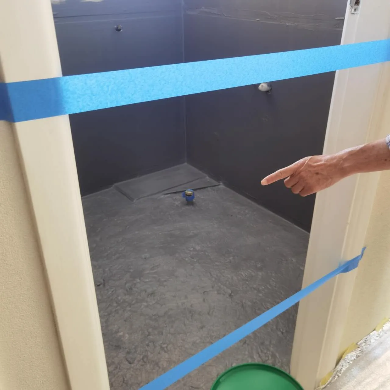 Owner-supplied bathroom renovation photo showing floor waterproofing and service penetrations