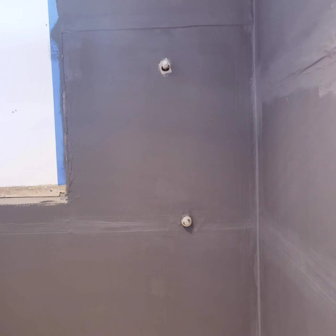 Owner-supplied bathroom project photo showing waterproofed walls and plumbing outlets