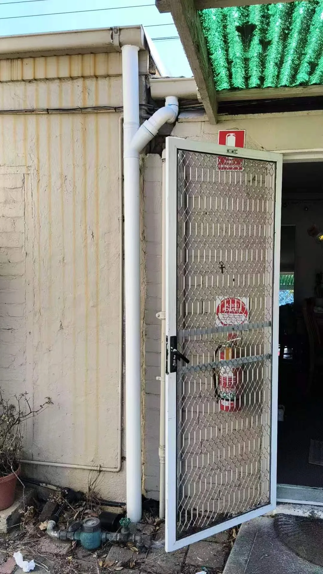 Owner-supplied completed visible-condition view of an exterior vertical drainage pipe