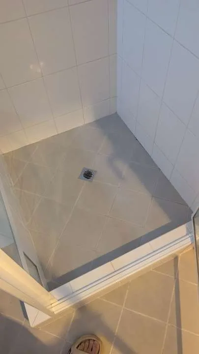 Owner-supplied completed-view photo of tiled shower falls and a floor waste