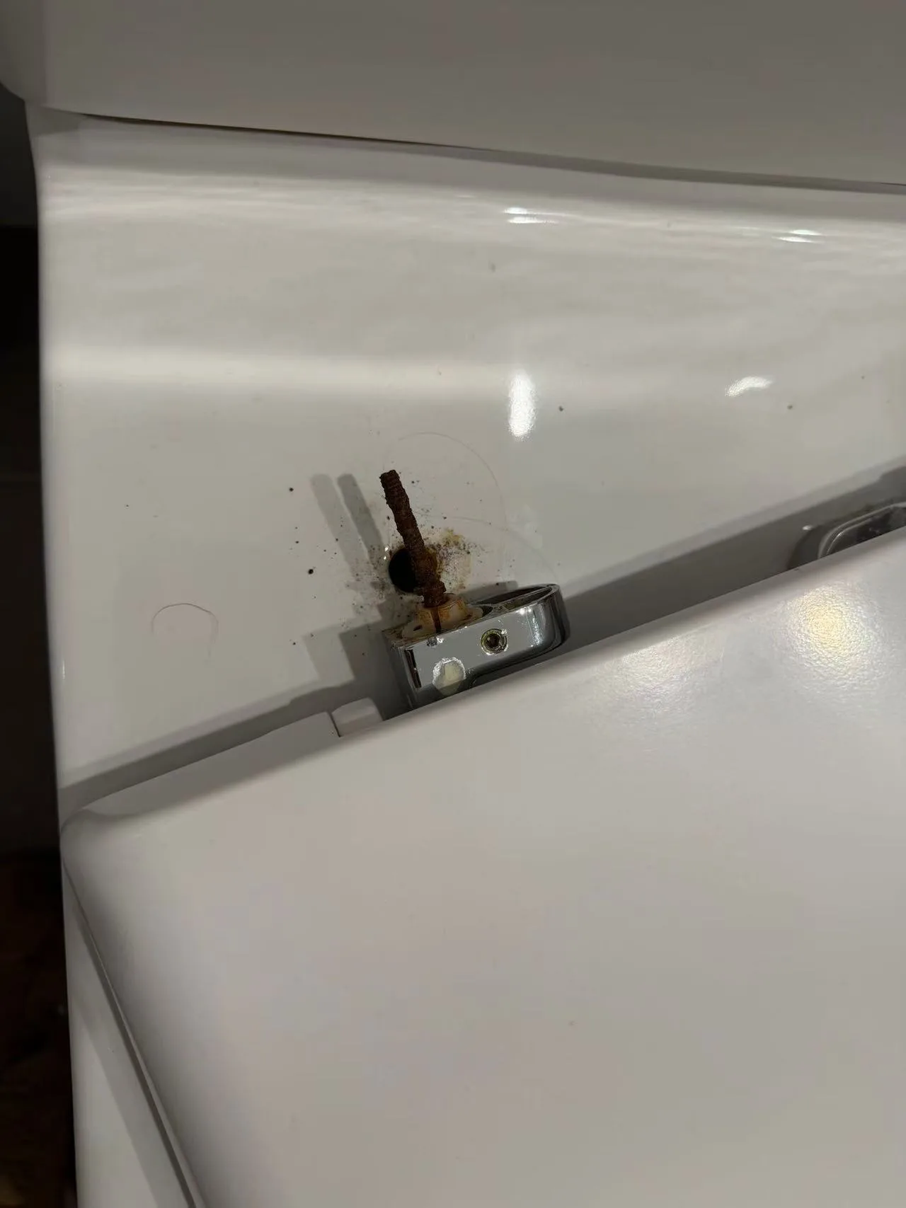 Owner-supplied project photo showing corrosion around a toilet fixing point