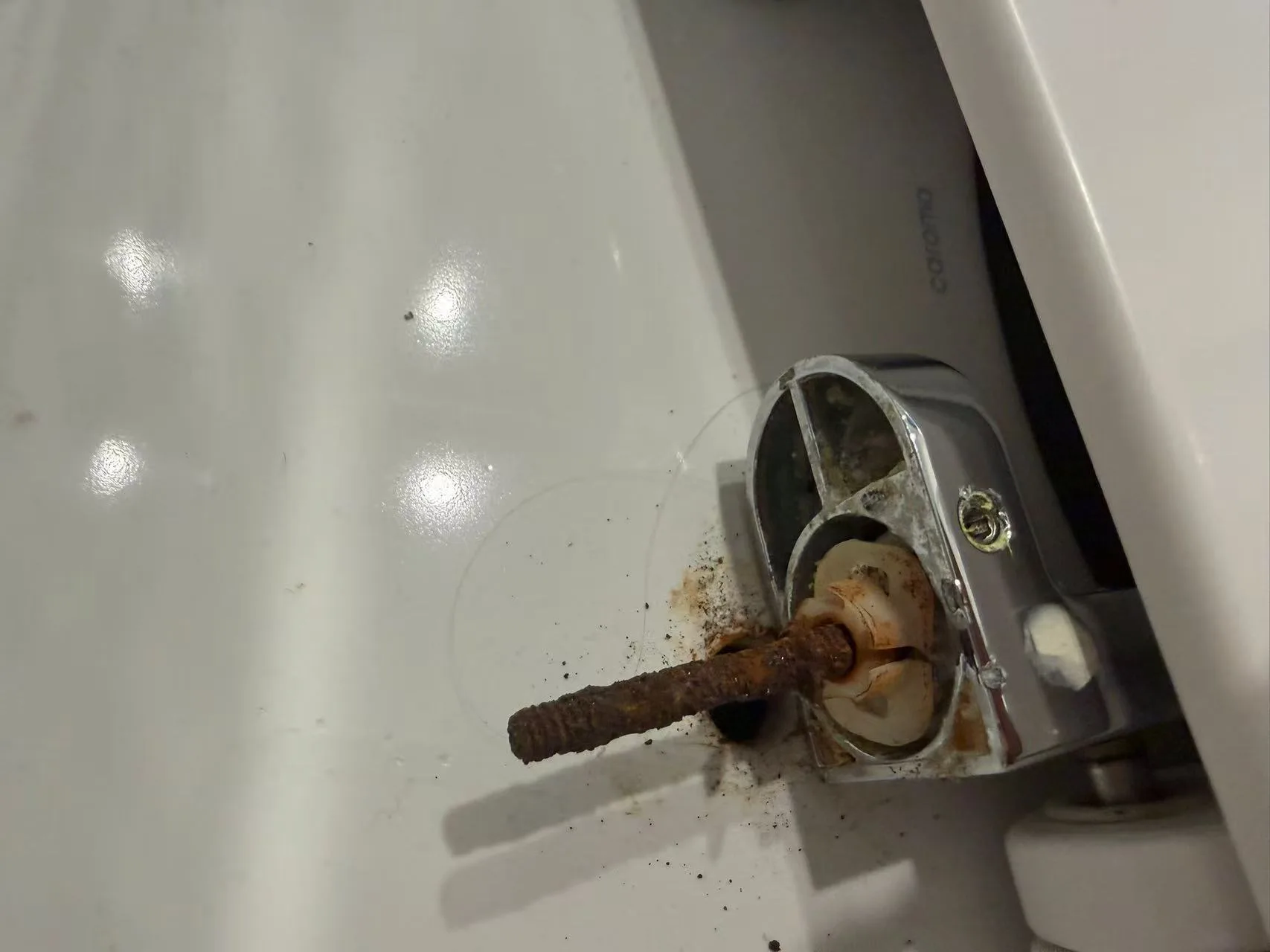 Owner-supplied detail view of wear and corrosion around a toilet fixing assembly