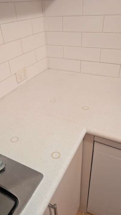 Completed kitchen work surface and tiled wall beside the sink